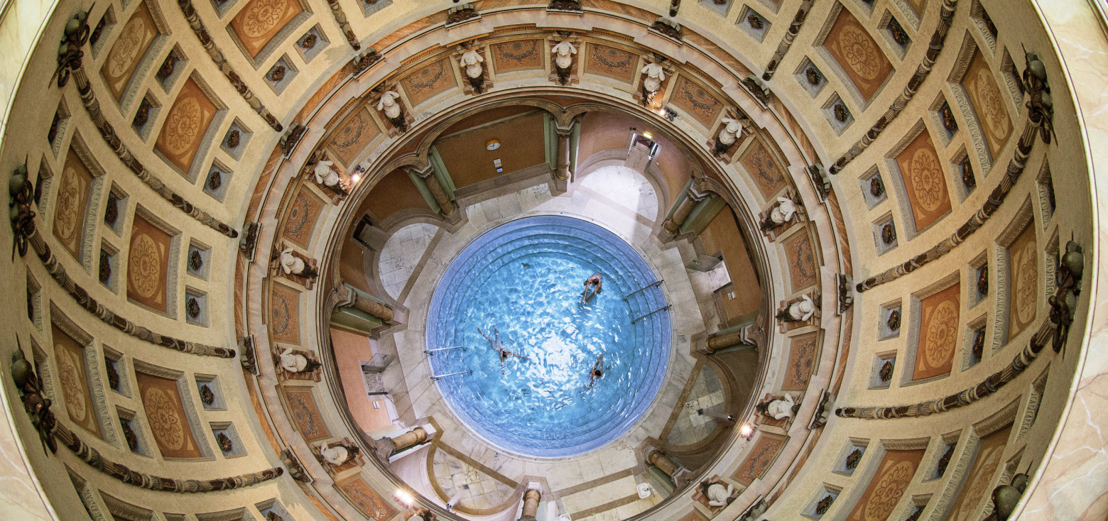 Blick von oben in das runde Kuppelbad des Friedrichsbads in Baden-Baden mit Badenden im zentralen Thermalbecken.
