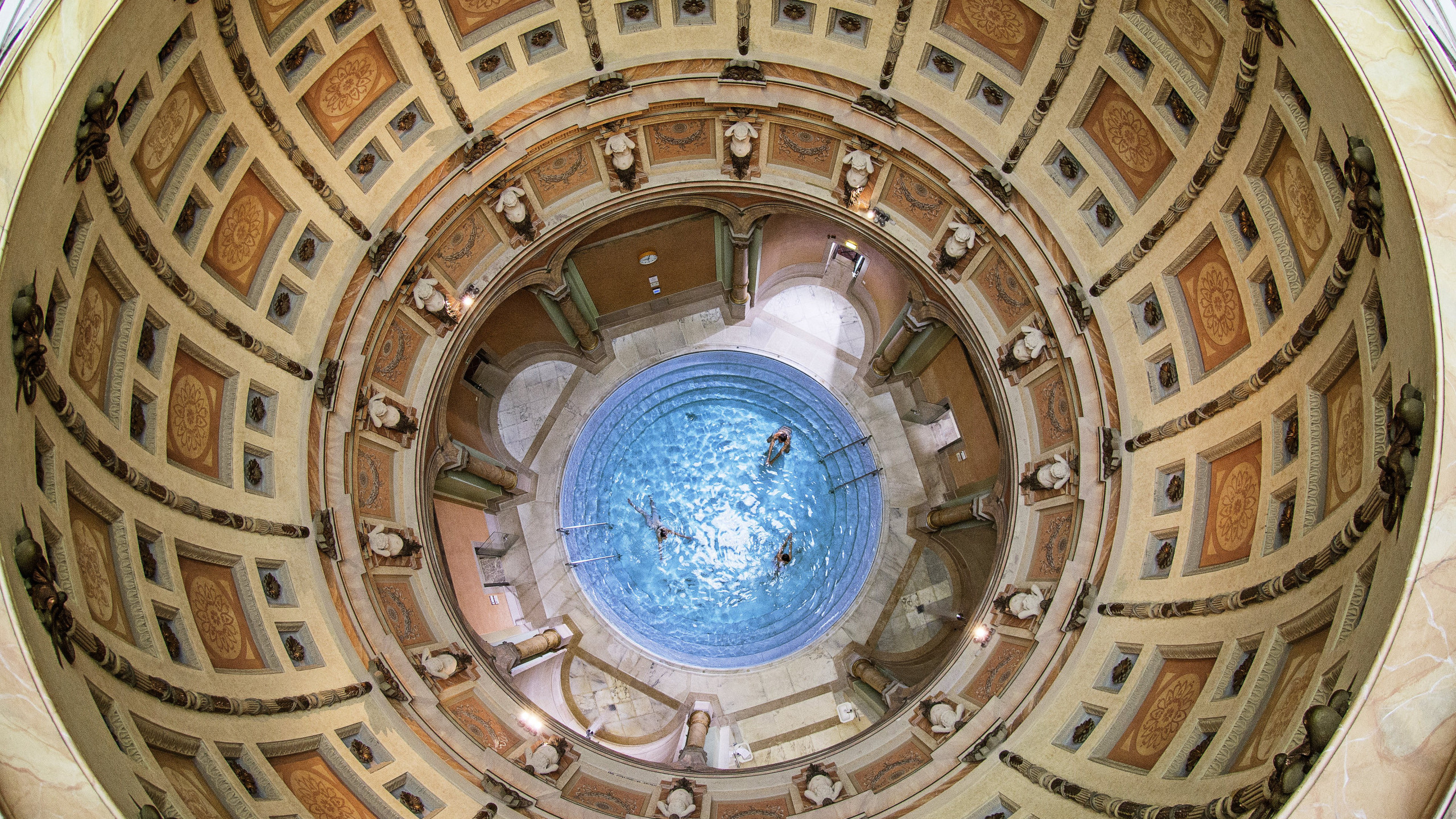 Blick von oben in das runde Kuppelbad des Friedrichsbads in Baden-Baden mit Badenden im zentralen Thermalbecken.